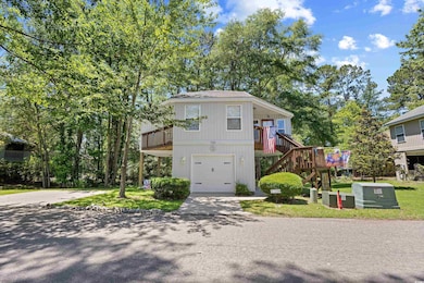 View of side of home featuring stairway, a garage, and concrete driveway