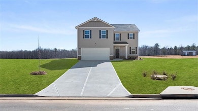 View of front of house with a garage, board and ba