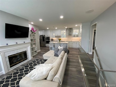 Living area featuring dark wood-style floors, recessed lighting, and a fireplace