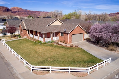 Ranch-style house with an attached garage, driveway, a front lawn, brick siding, and fence private yard
