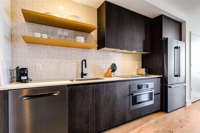 Kitchen featuring open shelves, a sink, light cou