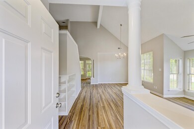 Hallway with beam ceiling, an inviting chandelier,