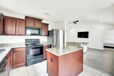 Kitchen featuring a kitchen island,  black appliances, Stainless steel fridge