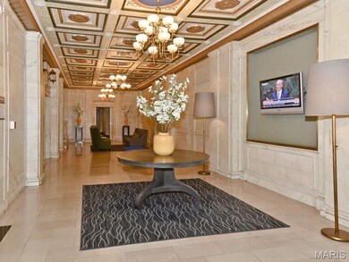 Community lobby featuring a decorative wall, ornamental molding, and coffered ceiling