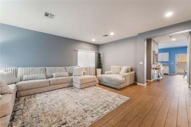 Living area with baseboards, visible vents, wood f