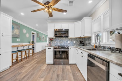 Kitchen featuring white cabinets, light hardwood /