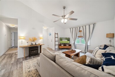 Living room with lofted ceiling, ceiling fan, and