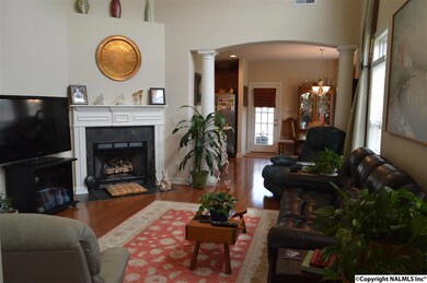 Living with lots of space. Large sofa, two recliners, coffee table, end tables, entertainment center, potted plants and still spacious.