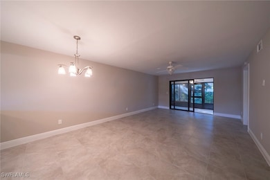 Empty room with ceiling fan, a chandelier, and light tile patterned floors