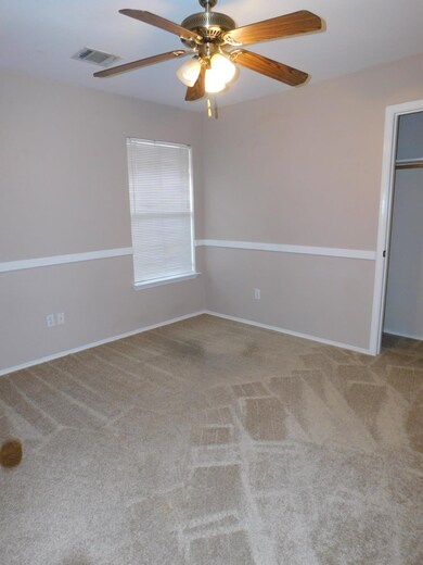 Carpeted empty room featuring ceiling fan and bas