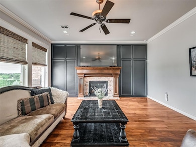 Living room featuring ceiling fan, ornamental mold