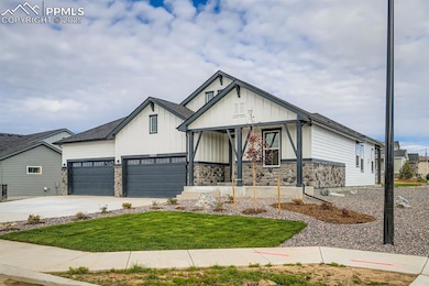 View of front of property featuring a porch, stone siding, board and batten siding, a front lawn, and concrete driveway