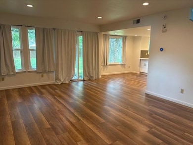 Unfurnished room with dark wood-style flooring, r