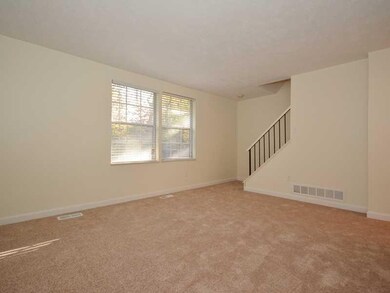 Living Room. Stairs tucked at the back of the livi