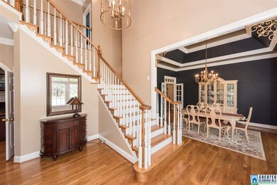 Welcoming foyer with hardwoods, crown molding, din