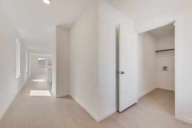 Corridor featuring light wood-type flooring and recessed lighting