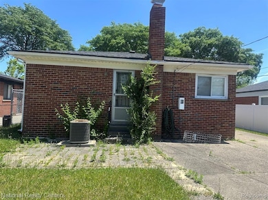 Back of property featuring brick siding, a chimney, and entry steps