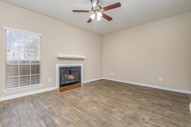 Unfurnished living room with ceiling fan, dark woo