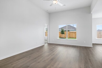 Spare room featuring dark wood-type flooring, a ceiling fan, and a high ceiling