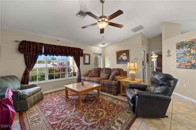 Living area with a ceiling fan, visible vents, vau