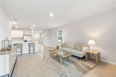 Living room with baseboards, light wood-type flooring, and recessed lighting