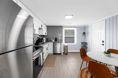 Kitchen with white cabinetry, ornamental molding, 