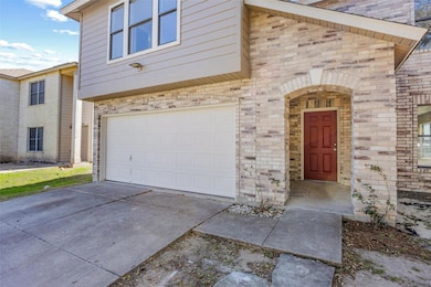 View of exterior entry with a garage, brick sidin