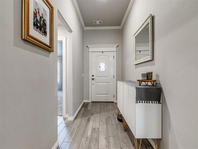 Foyer with baseboards, visible vents, light wood-s