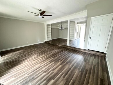 Unfurnished great room featuring dark wood-type fl