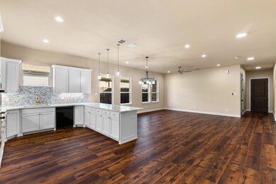 Kitchen with white cabinetry, dark hardwood / wood