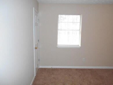 Carpeted spare room featuring baseboards