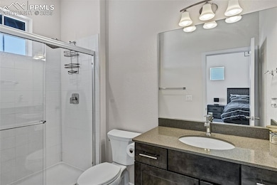 Full bath featuring ensuite bathroom, a shower stall, and vanity