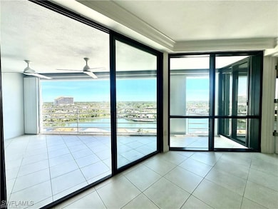 Doorway with a water view, a wall of windows, tile patterned floors, and ceiling fan