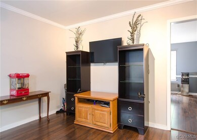 The game room has laminate flooring, crown molding