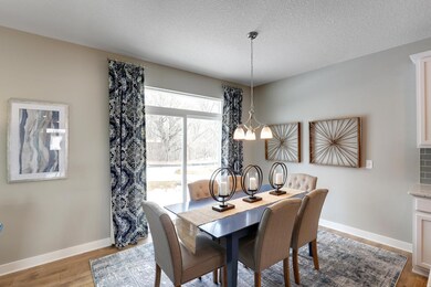 Dining room adjacent to the kitchen and living space, conveniently located next to the doors leading out to the patio!  *Photo is of a model home.  Finishes in actual home may differ.