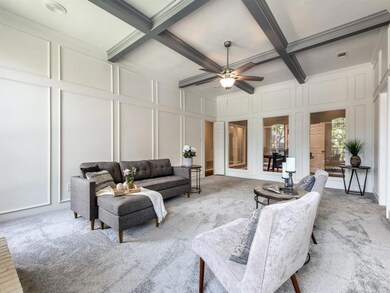 White paneled walls and coffered ceilings with charcoal gray beams