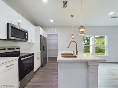 Kitchen with white cabinets, a center island with