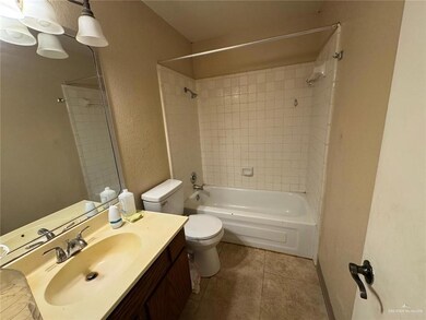 Full bathroom featuring vanity, shower / washtub combination, tile patterned floors, toilet, and a textured wall