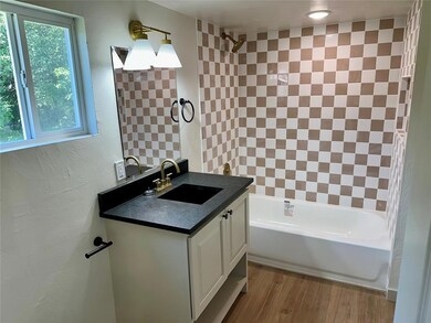 Full bath with vanity, shower / tub combination, and wood finished floors