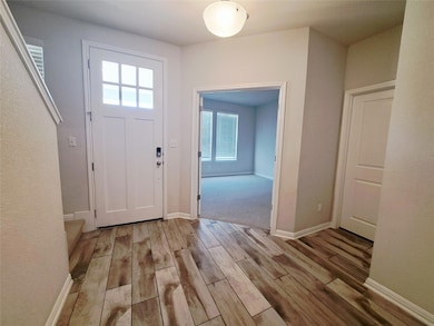 Entryway with baseboards and light wood-style flo