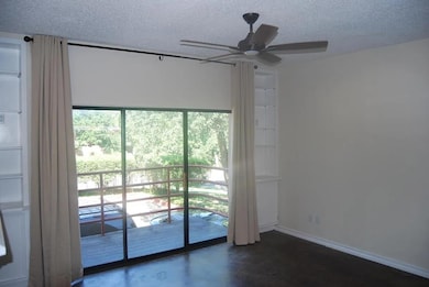 Empty room featuring finished concrete floors, a textured ceiling, and ceiling fan