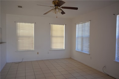 Living room with lots of windows, tile flooring and ceiling fan