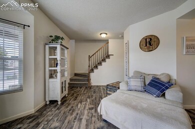Bedroom with a textured ceiling, baseboards, and d