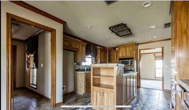 Kitchen with stainless steel appliances, dark tile floors, tasteful backsplash, and ornamental molding