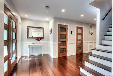 Alternate view of the foyer with wooden stairs lea