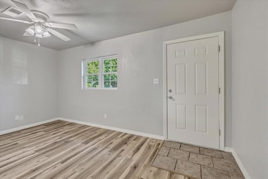 Foyer entrance with light wood-style floors and a ceiling fan