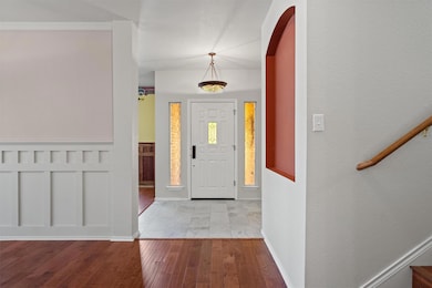 Foyer with wood finished floors, arched walkways,