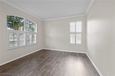 Empty room with baseboards, crown molding, and dar