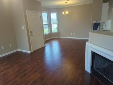 Unfurnished living room featuring crown molding, dark wood finished floors, and a fireplace