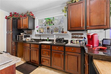 Kitchen featuring dark countertops, a sink, crown 